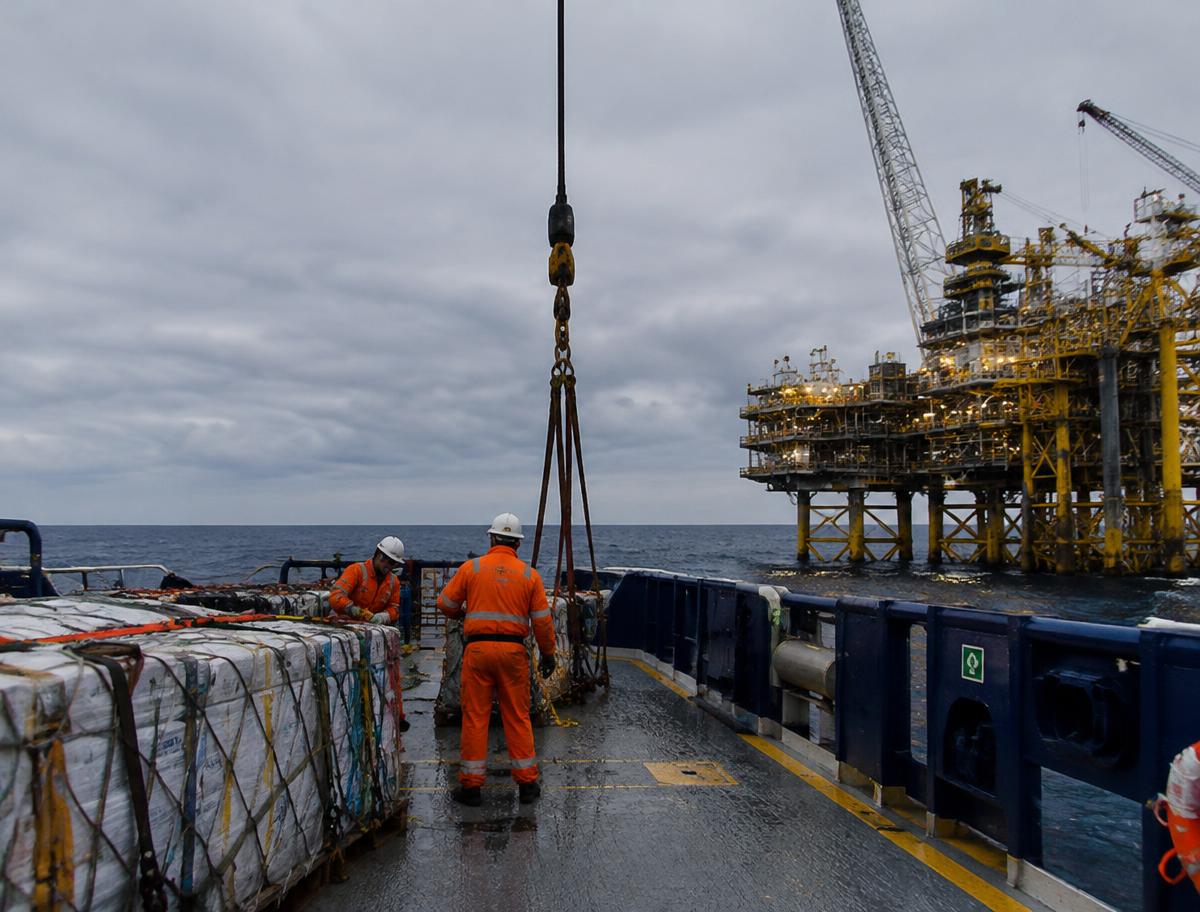 Tripulação operando carga no convés de embarcação de apoio offshore